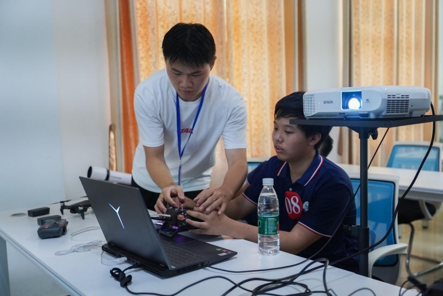 beat365正版唯一入口必一信息工程学院学生正在指导研学团成员操控无人机。